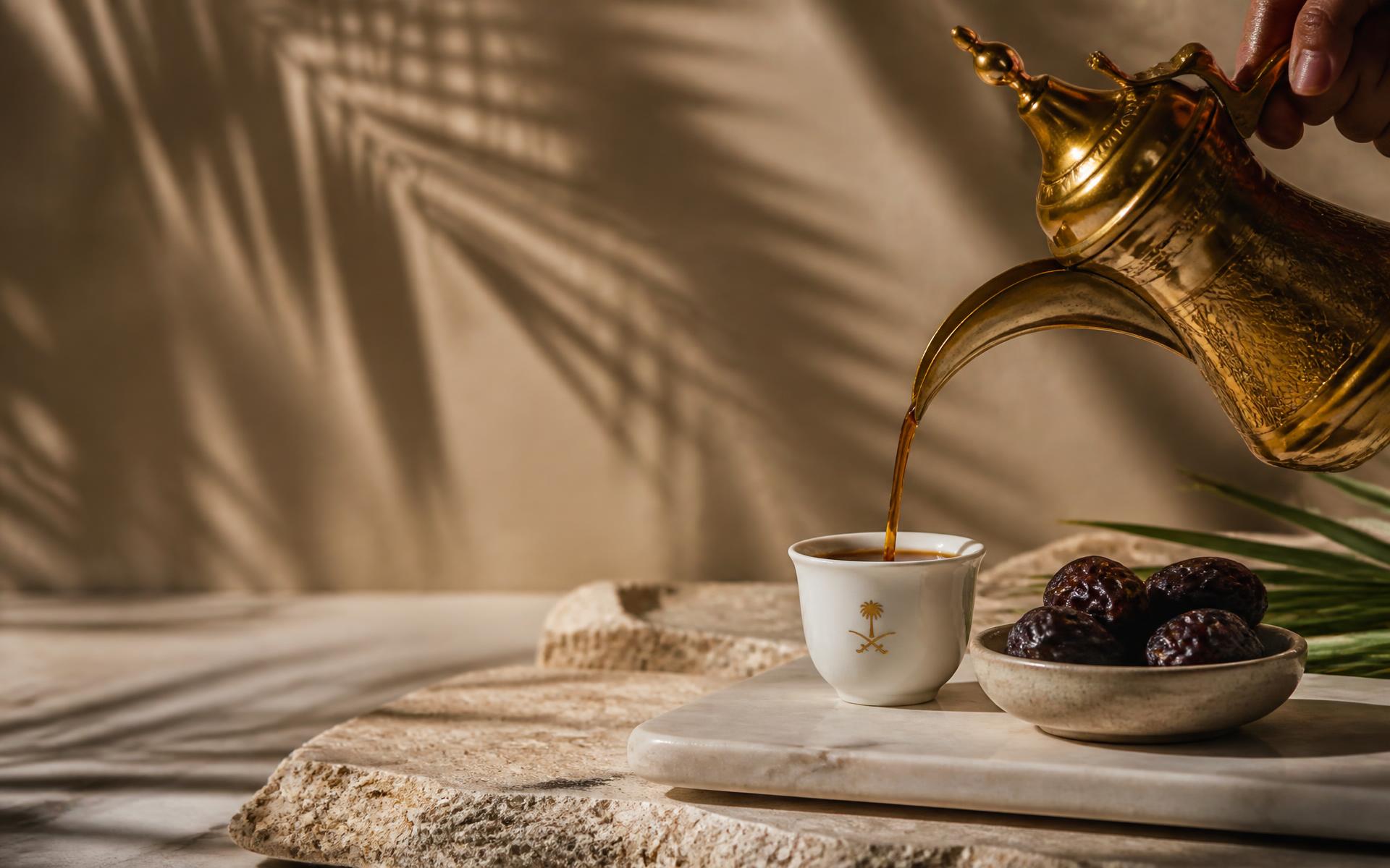 Saudi coffee poured from a brass dallah into a finjan beside Ajwa dates